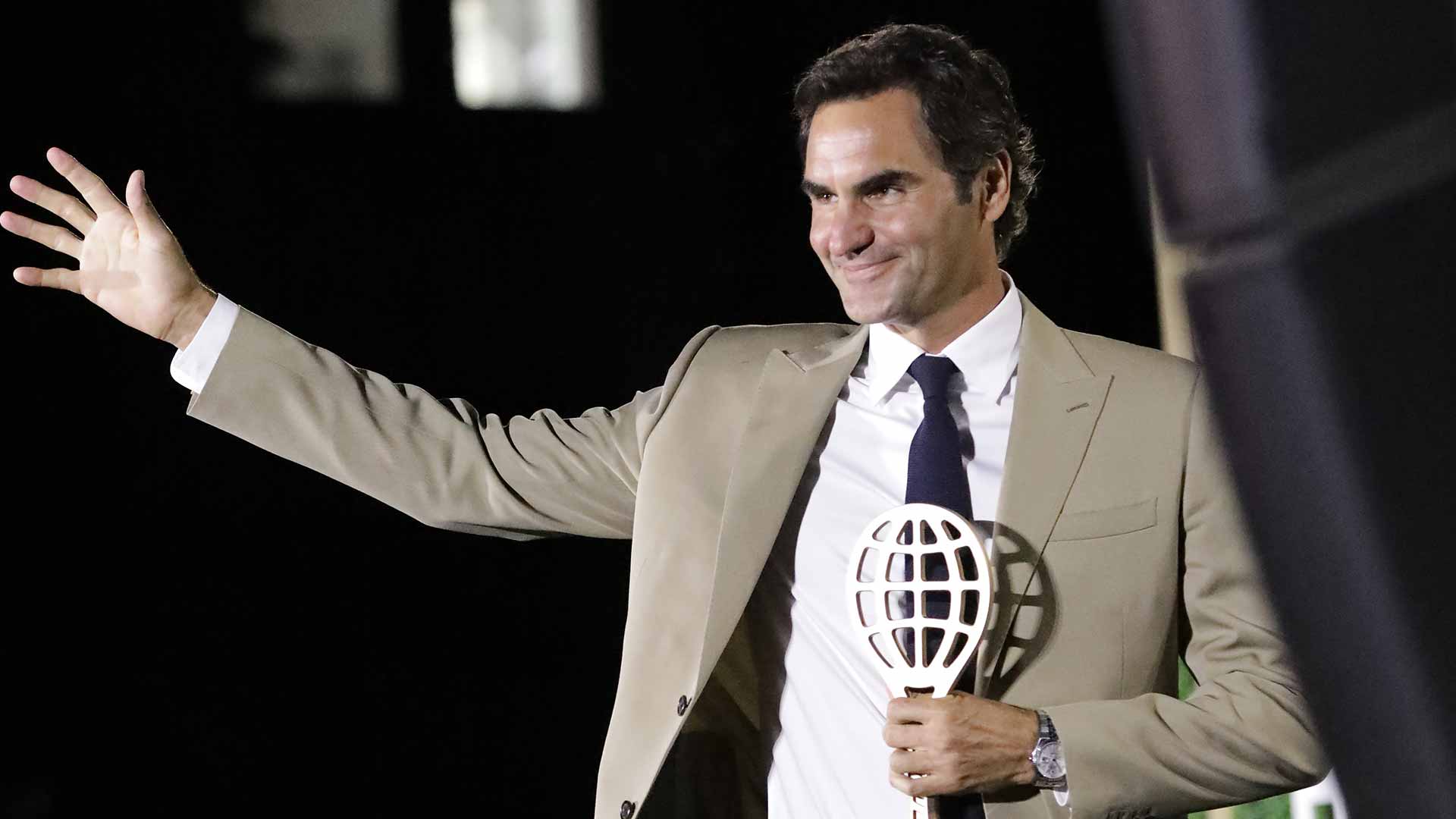 Roger Federer waves to the crowd at the International Tennis Hall of Fame in Newport, Rhode Island on Saturday evening.